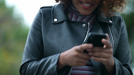 Black woman celebrates good news notification on smartphone