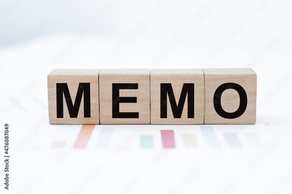 Poster memo word on wooden cubes on the background of colored graphs on the table