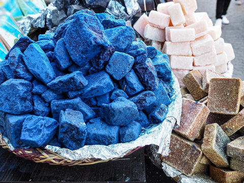Blue indigo color stones and natural handmade soaps displayed at traditional souk - street market in Marrakech, Morocco, closeup detail