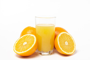 Freshly squeezed orange juice on a white background. A glass of orange juice and a cut orange next to it. Refreshing natural fruit juice