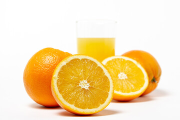 Freshly squeezed orange juice on a white background. A glass of orange juice and a cut orange next to it. Refreshing natural fruit juice