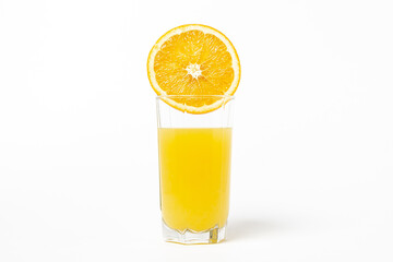 Freshly squeezed orange juice on a white background. A glass of orange juice and a cut orange next to it. Refreshing natural fruit juice