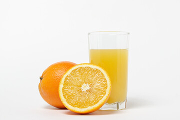 Freshly squeezed orange juice on a white background. A glass of orange juice and a cut orange next...