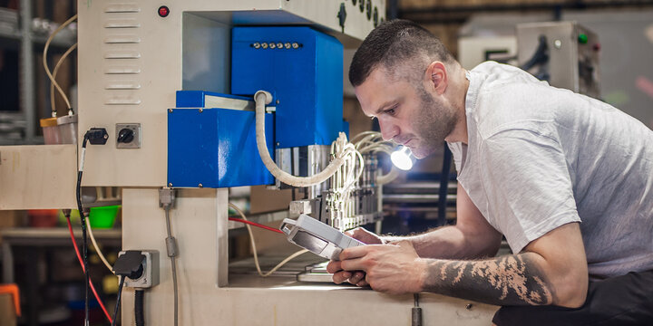 Worker technician engineer programming soft PVC dispensing machine in factory
