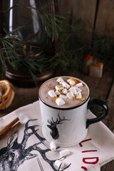 Cocoa with marshmallows and citrus zest on christmas background