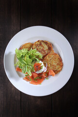Potato pancakes with red salmon fish. Caviar and poached egg on potato pancakes. The concept of the restaurant menu. Top view with copy space.Flat lay.Vertical photo.
