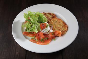 Potato pancakes with red salmon fish. Caviar and poached egg on potato pancakes. The concept of the restaurant menu. Top view with copy space.Flat lay.