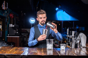 Bartender mixes a cocktail in the bar