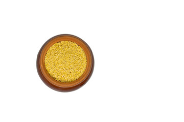 yellow millet seeds in large ceramic pot isolated on white background