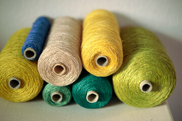 Set of cord in shades of green close-up..Retro style threads on spool in workshop. Equipment to creative DIY hobby hand works like embroidery. Colourful string, yarn on the roll.