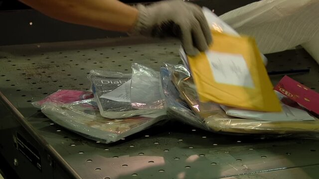 Postal Worker sorting Mail at a Dumping Station of the Argentine Post Service. Close Up. 