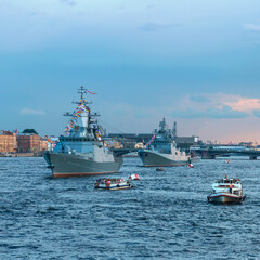Modern warships. Tourists from pleasure ships and the embankment look at the warships on the Neva....