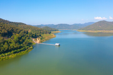 Fototapeta na wymiar Aerial top view of a dam with forest trees, lake, river, mountain hills in travel and environment concept. Nature landscape background in Thailand.