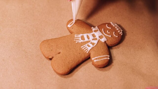 Decorating a gingerbread man with sugar glaze. Selective focusing.