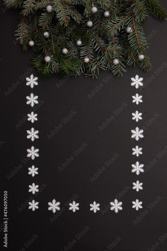 Poster branches with snowballs on a black background with copy space framed with snowflakes