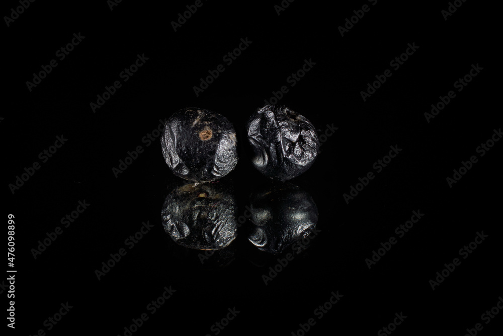 Poster closeup of two metallic asteroid 3d rendering reflecting over a shiny black background