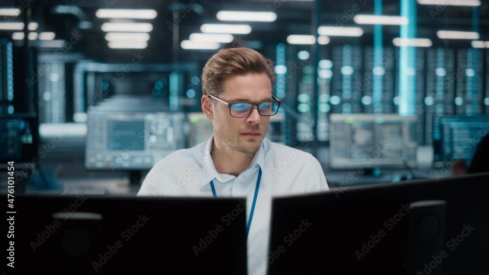 Wall mural high-tech data center server control: it specialist administrator working on computer, screen showin