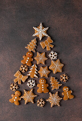 Obraz na płótnie Canvas Christmas tree made of gingerbread cookies on brown background, Flat lay, Top view