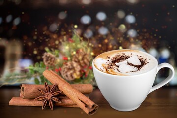 Hot drink with marshmallows in a mug. Fir cones, spices in the background.