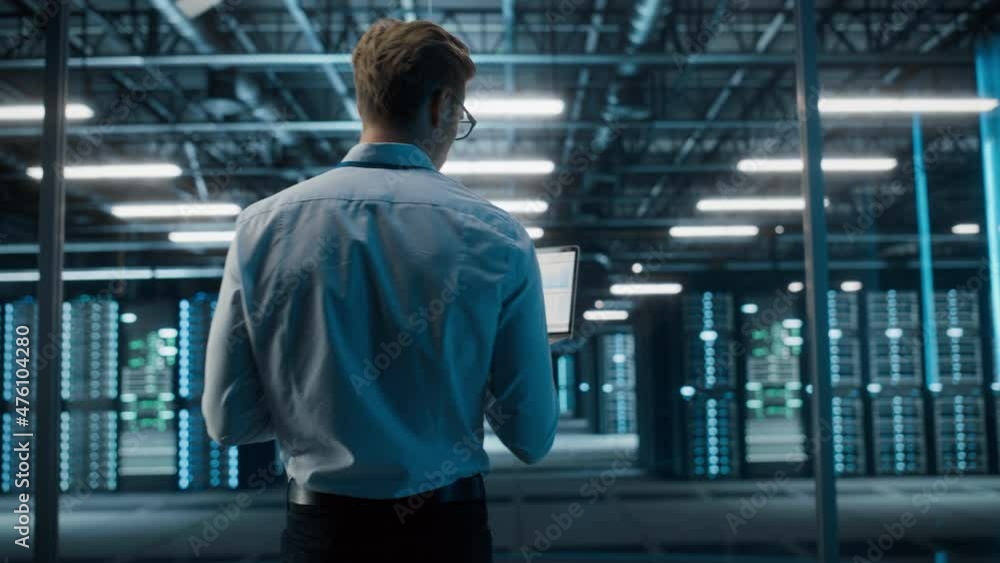 Poster Big Data Center Specialist Engineer Standing, Using Laptop Computer. Cloud Computing Facility with System Administrator Working. Software as Solution, Cyber Security. Rack Focus on Servers