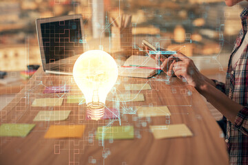 Double exposure of woman hands typing on computer and light bulb drawing. Idea concept.