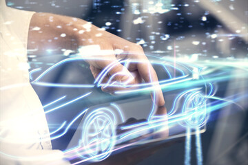 Double exposure of man's hands holding and using a digital device and automobile theme hologram...