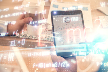 Double exposure of man's hands holding and using a phone and formulas drawing. Education concept.