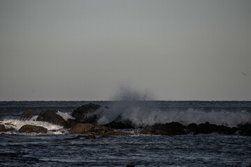 Haciendo surf en la playa de Sopelana, en Bizkaia, con el peñon de fondo.