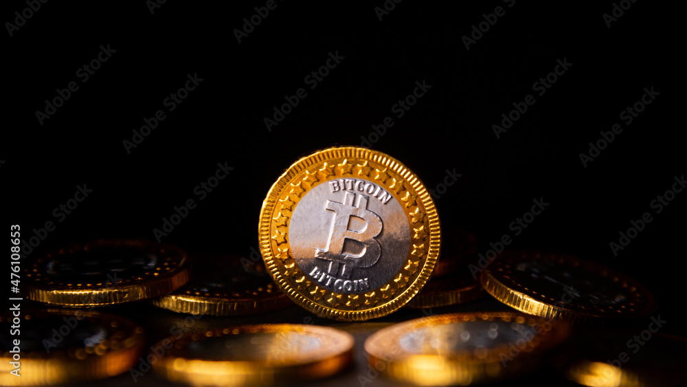 Poster selective focus of bitcoin gold coin on a heap of bitcoin coins with a black background