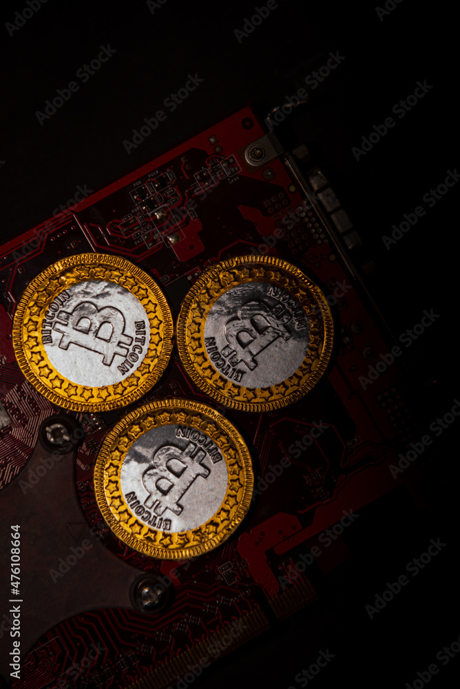 Poster top view of bitcoin coins on a red video card background, blockchain and bitcoin mining concept