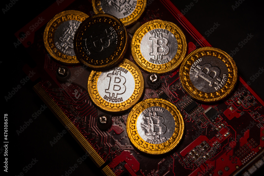 Poster top view of bitcoin coins on a red video card background, blockchain and bitcoin mining concept