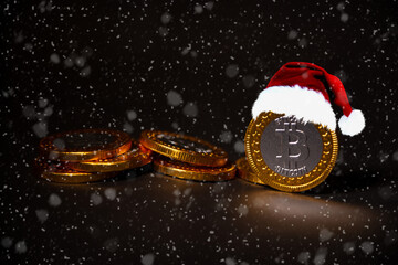 Bitcoin currency with Christmas fez on a heap on coins with snow weather around