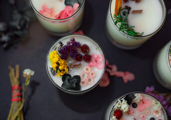 Soy wax candles decorated with natural materials top view. Low key photo. Creative gift idea. Candle making workshop table.