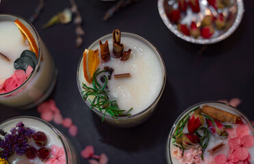 Soy wax candles decorated with natural materials top view. Low key photo. Creative gift idea. Candle making workshop table.	
