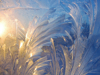 Beautiful ice pattern and sunlight closeup on winter window glass