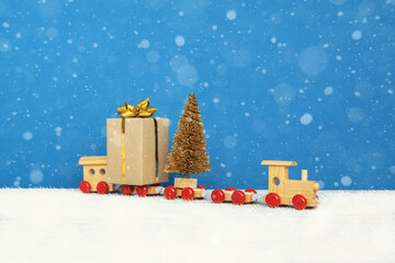 Merry Christmas and happy New Year card celebration old craft styling, toy train with Christmas presents box on blue holidays background