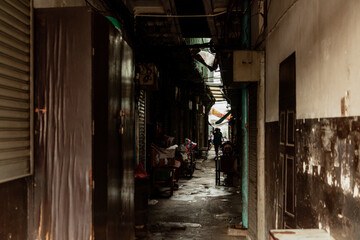 Narrow dark lane between buildings, Bangkok, Thailand