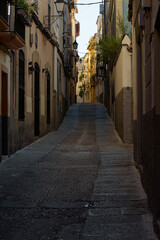 Fototapeta na wymiar View of a narrow street with stone buildings in the old town of Plasencia at dawn, Caceres, Extremadura, Spain