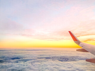Fototapeta na wymiar Airplane wing in the sky at beautiful sunset, airplane flight in the sky with copy space