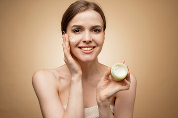 The woman uses applied a new facial cream, moisturizing and scrub. The model shows cosmetics.