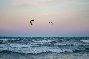 Windsurfing at sunset on a cullera beach. calm sea and vivid colors in the sky