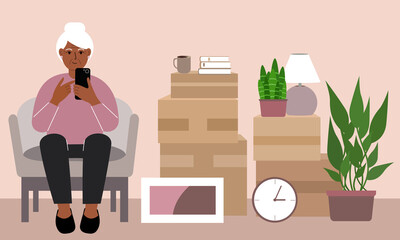Grandmother at home with a mobile, phone sits in a chair. The concept of online registration of delivery of boxes, goods and assistance in moving.