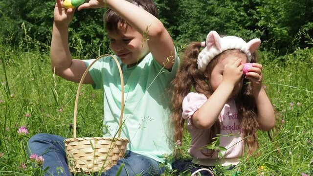 happy children celebrate easter. boy and girl collect Easter eggs in the grass. Children having fun in park. Easter egg hunt concept