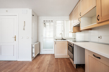 Newly installed kitchen cabinets on the wall of a vacation rental apartment with oak parquet floors