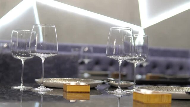 At a set table in an elite restaurant, empty wine glasses.