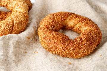 Fresh baked traditional turkish simit sesame bagels  on beige rough linen