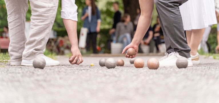 Bocce players collect boules after petanque outdoor game in city park