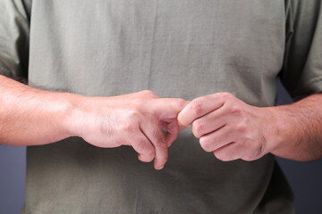 Fototapeta premium Closeup male hand, try to rub his middle finger to reduce pain, finger arthritis or finger trigger symptom