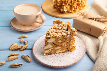 Traditional lithuanian cake shakotis with cup of coffee on blue, side view, close up.