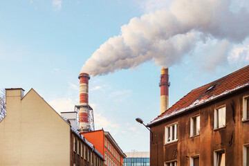 Air pollution by smoke coming out of a large factory chimney. A close-up of smoke coming out of chimneys against the blue sky. Air pollution concept, air emissions
